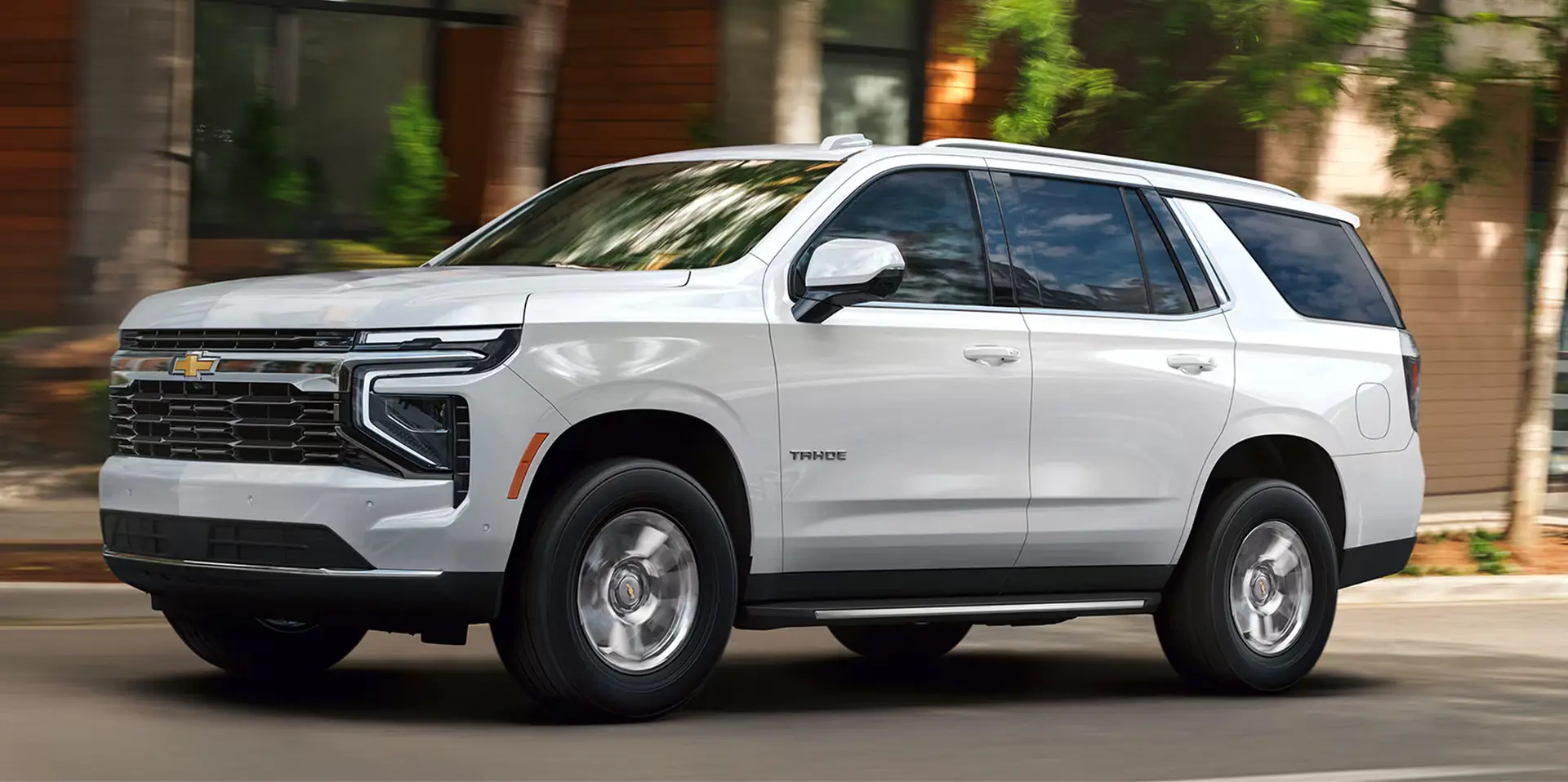A white suv driving on the road.