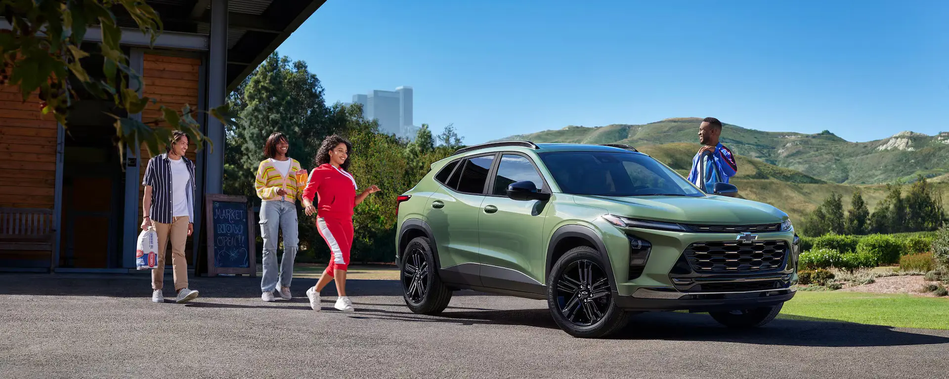 A family walking towards a green suv.