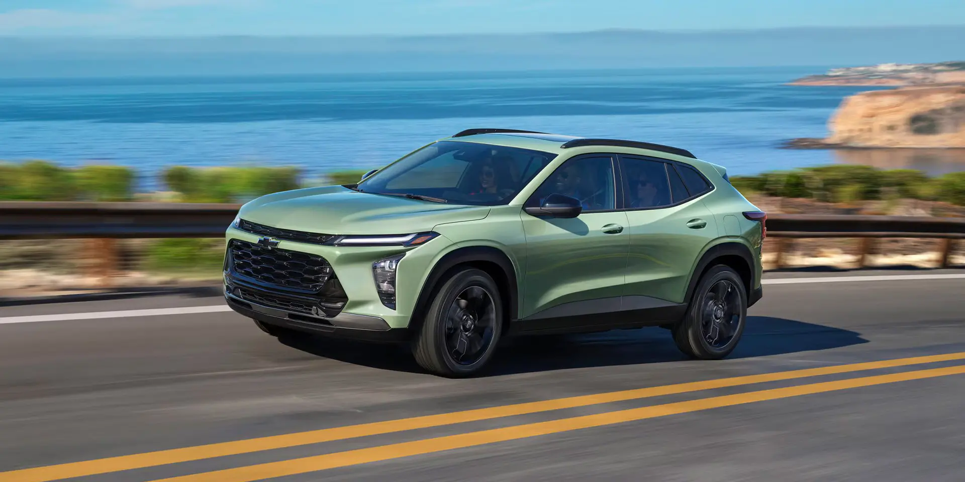 A green suv driving on the road.