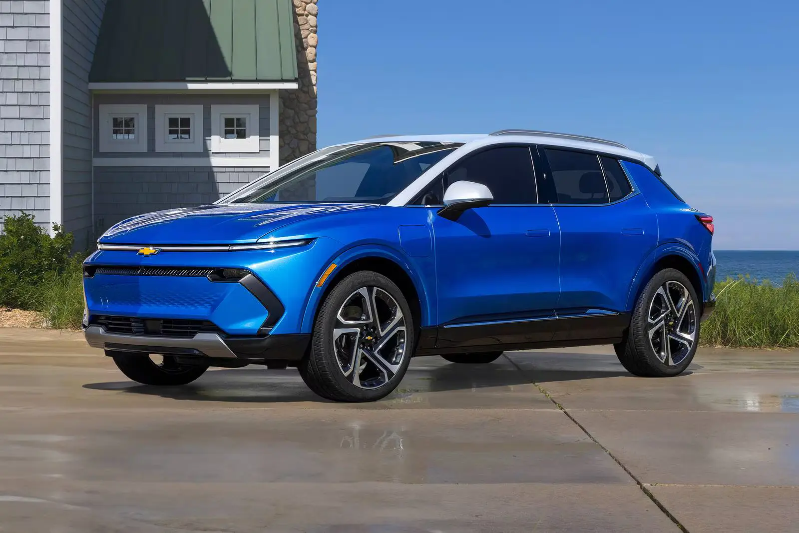 a blue blazer ev parked next to a house.