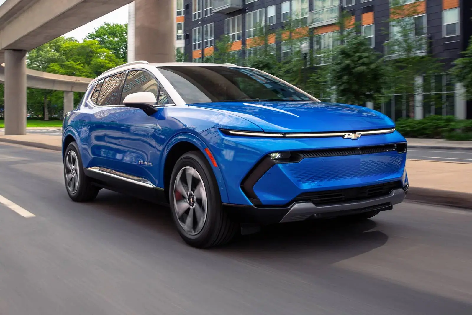 A blue suv driving on the road.