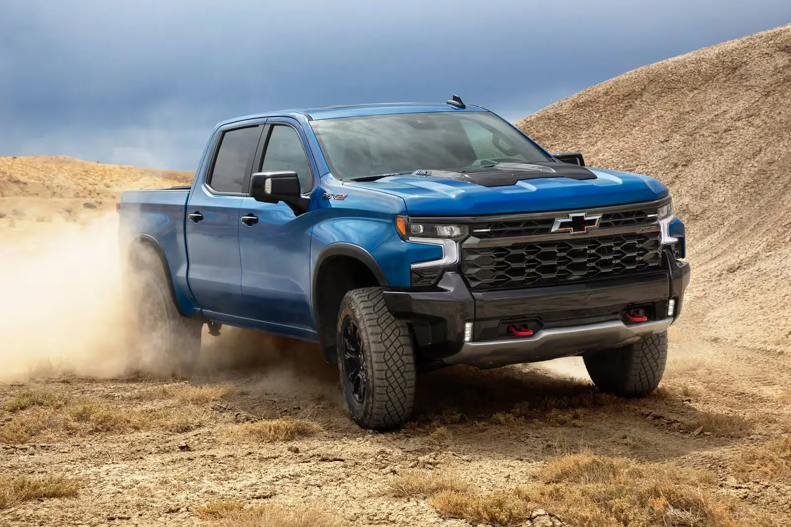 A blue truck driving off-road.