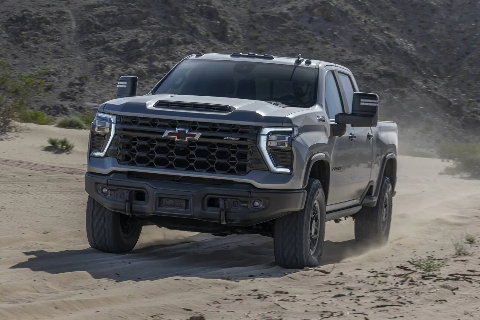A gray truck driving off-road.