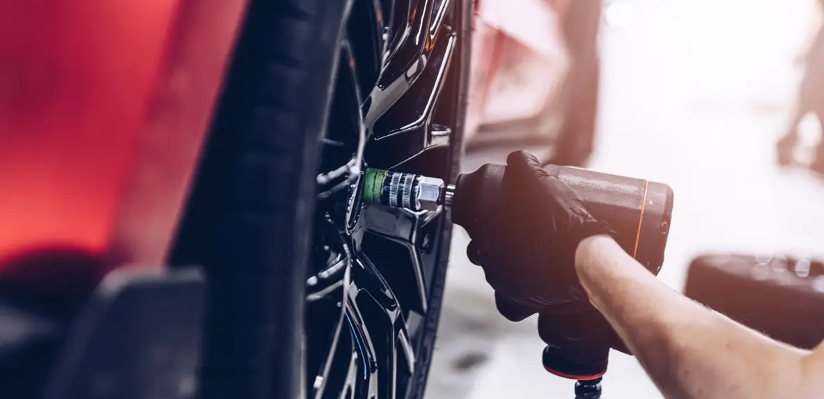 Mechanic tightening a wheel during tire and maintenance service