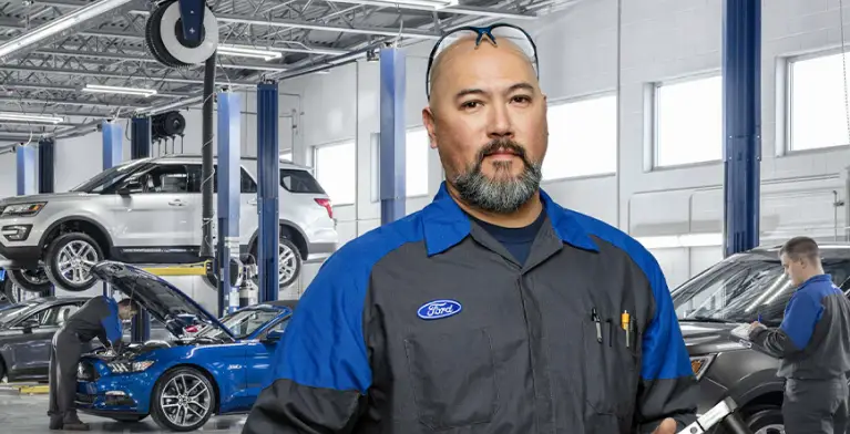Ford service technician standing in a dealership service department