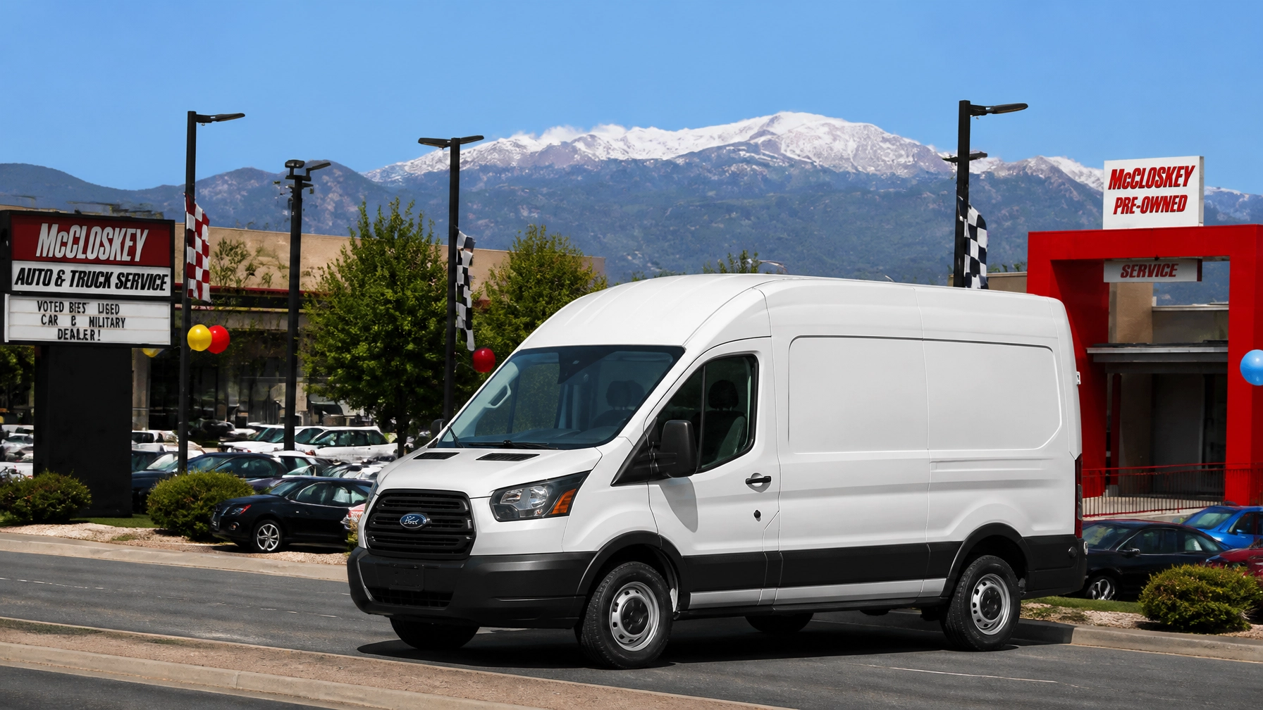Professional white cargo van at a Colorado Springs dealership with Pikes Peak in the background