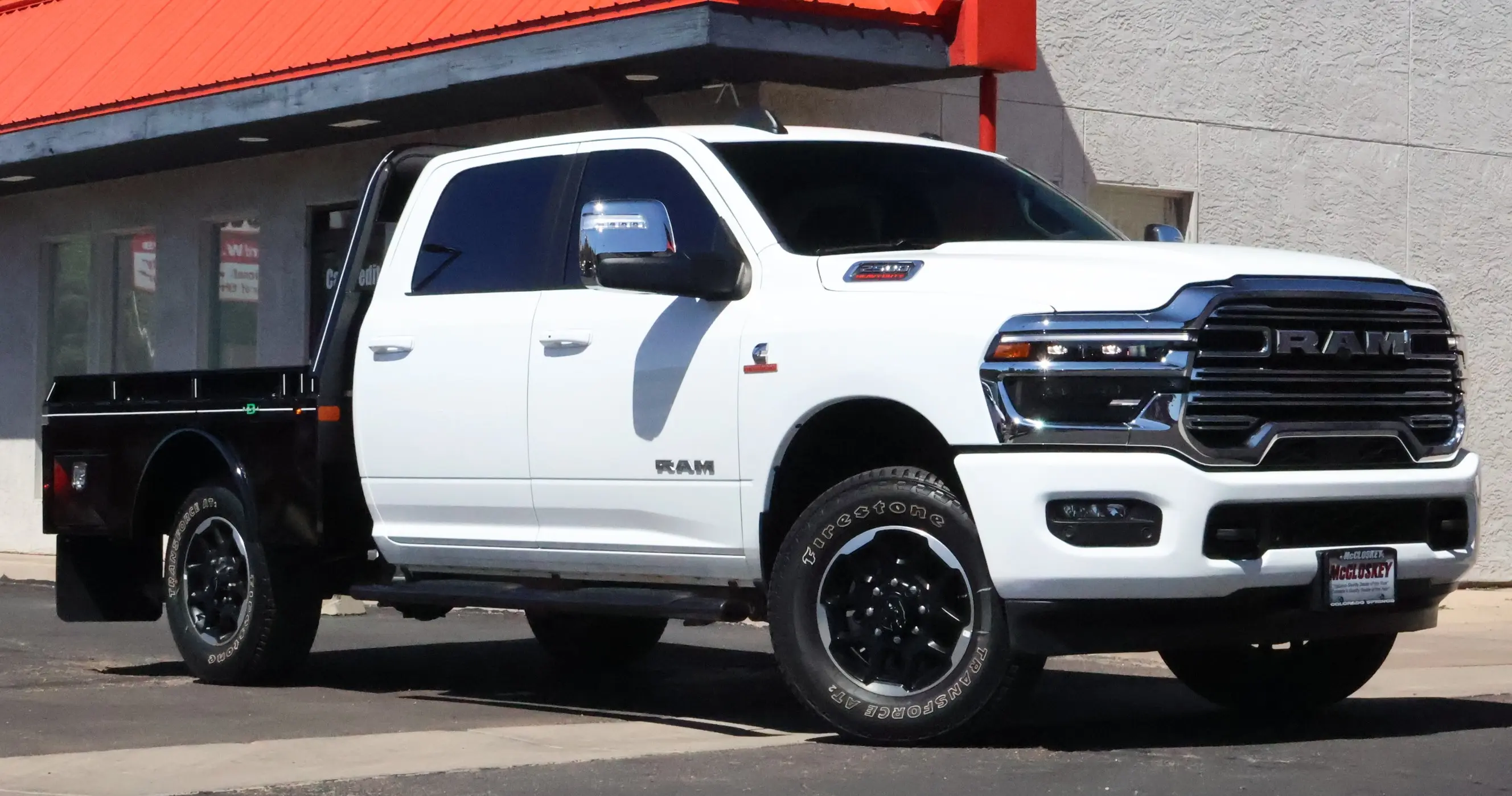 White RAM heavy-duty truck with a Butler flat bed installed, parked at McCloskey Motors in Colorado Springs