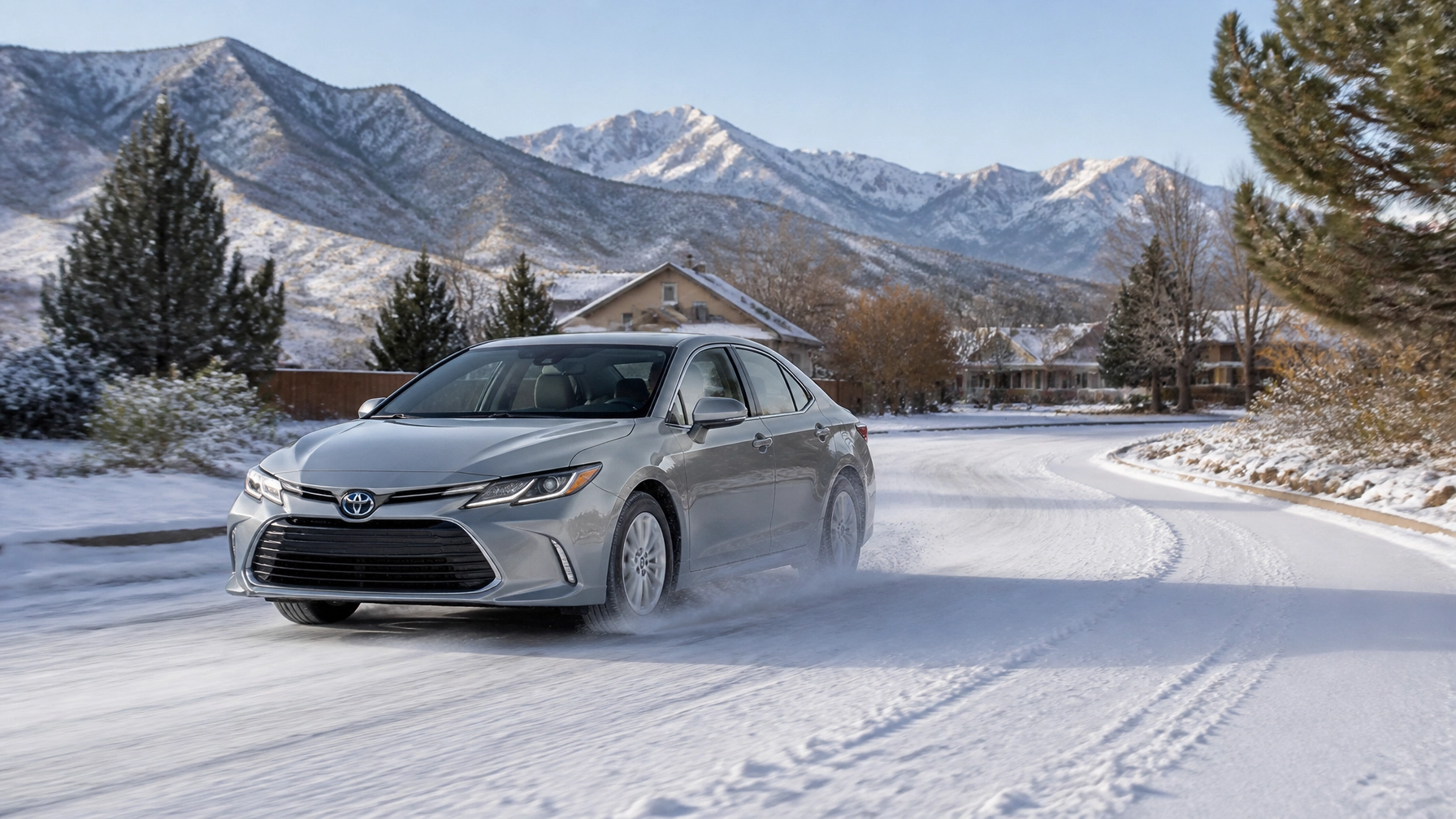 A hybrid sedan driving through a light dusting of snow on a crisp morning in Colorado Springs, showing the vehicle's capability in winter conditions