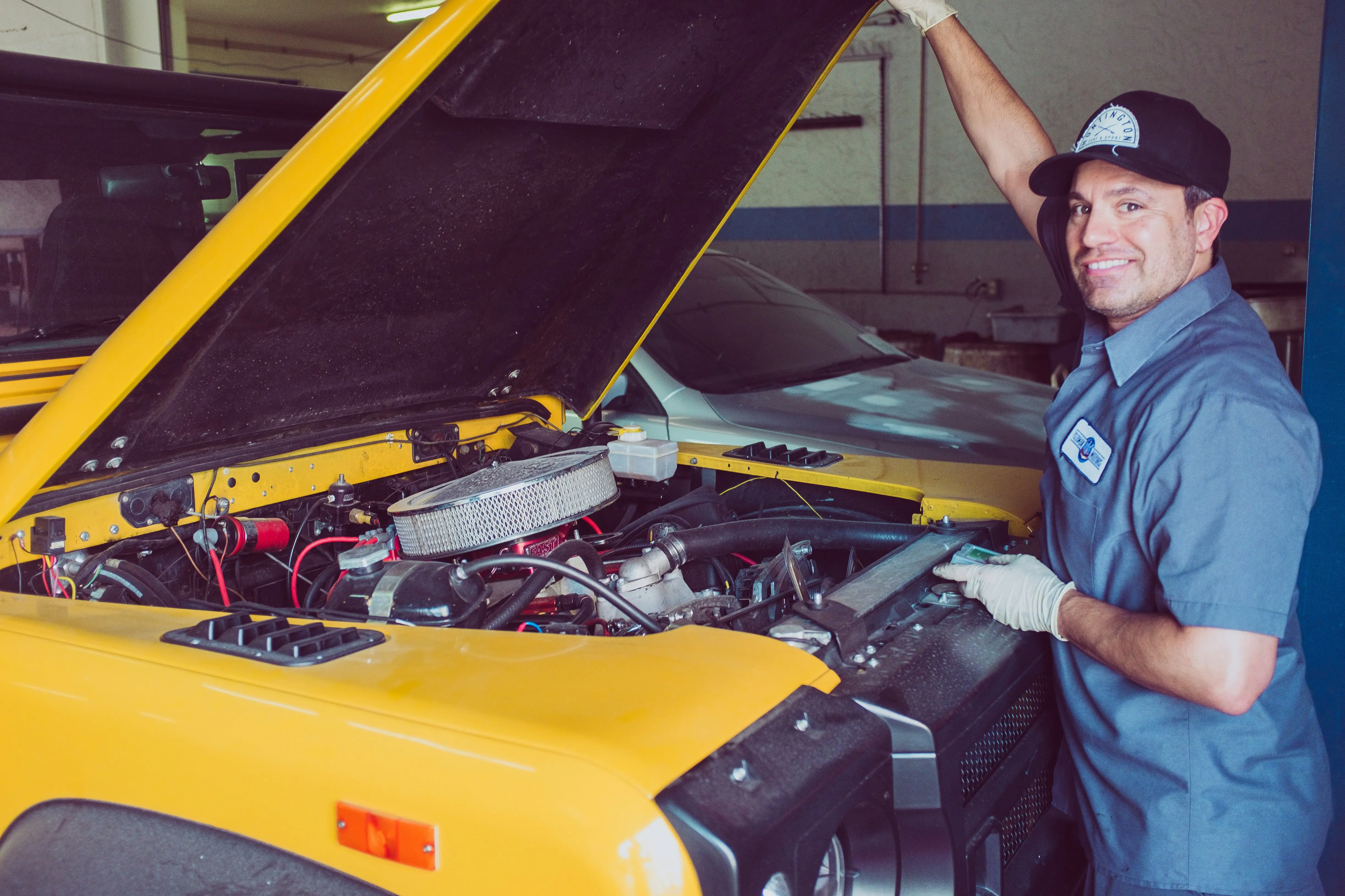 A mechanic in front of a vehicle.