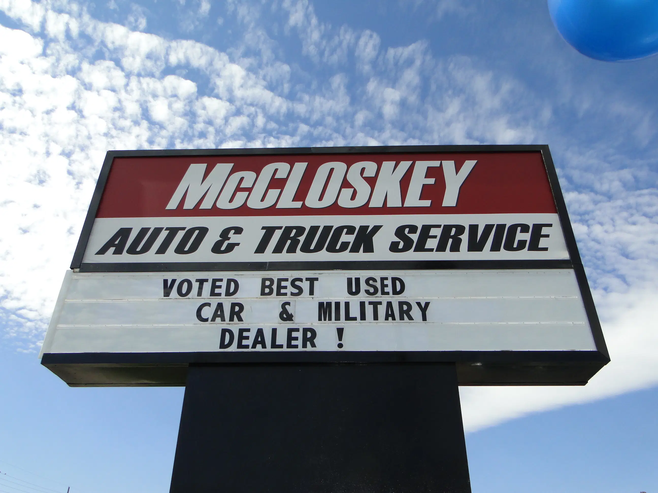 Outdoor sign at McCloskey Auto & Truck Service location highlighting community recognition