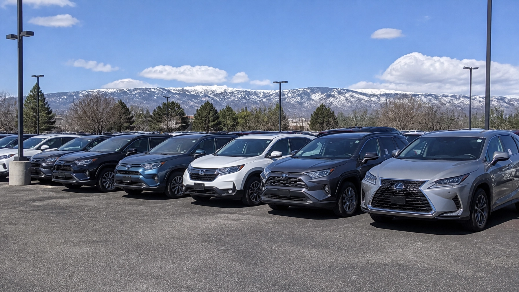 A shot of the McCloskey Motors lot on Academy Boulevard with a mix of hybrid and gas SUVs