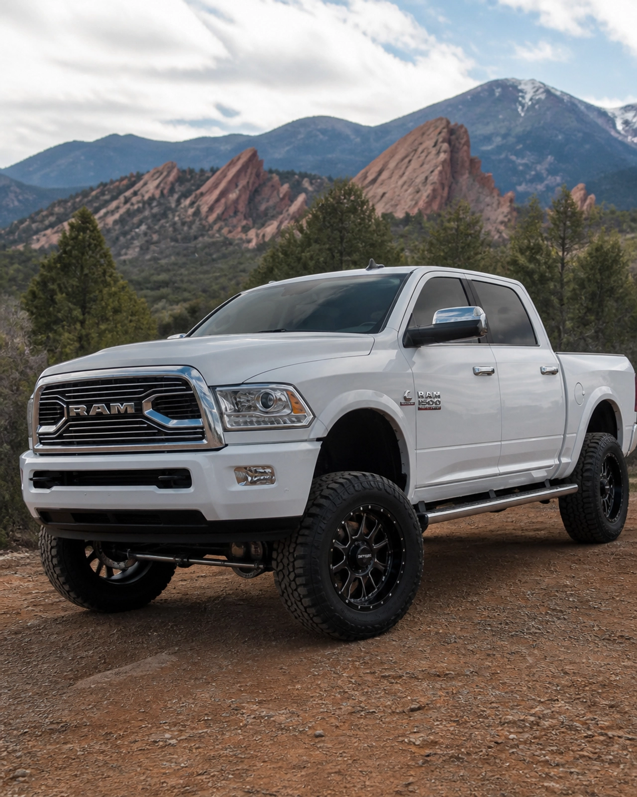 Lifted white RAM 1500 parked on a rocky overlook near Colorado Springs at McCloskey Truck Town in Colorado Springs CO
