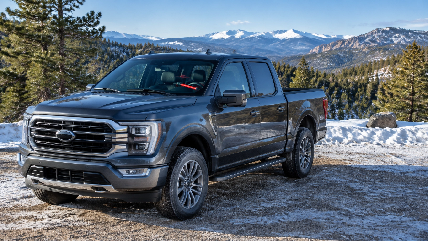 Locked pickup truck with a steering wheel lock parked at a snowy Colorado trailhead