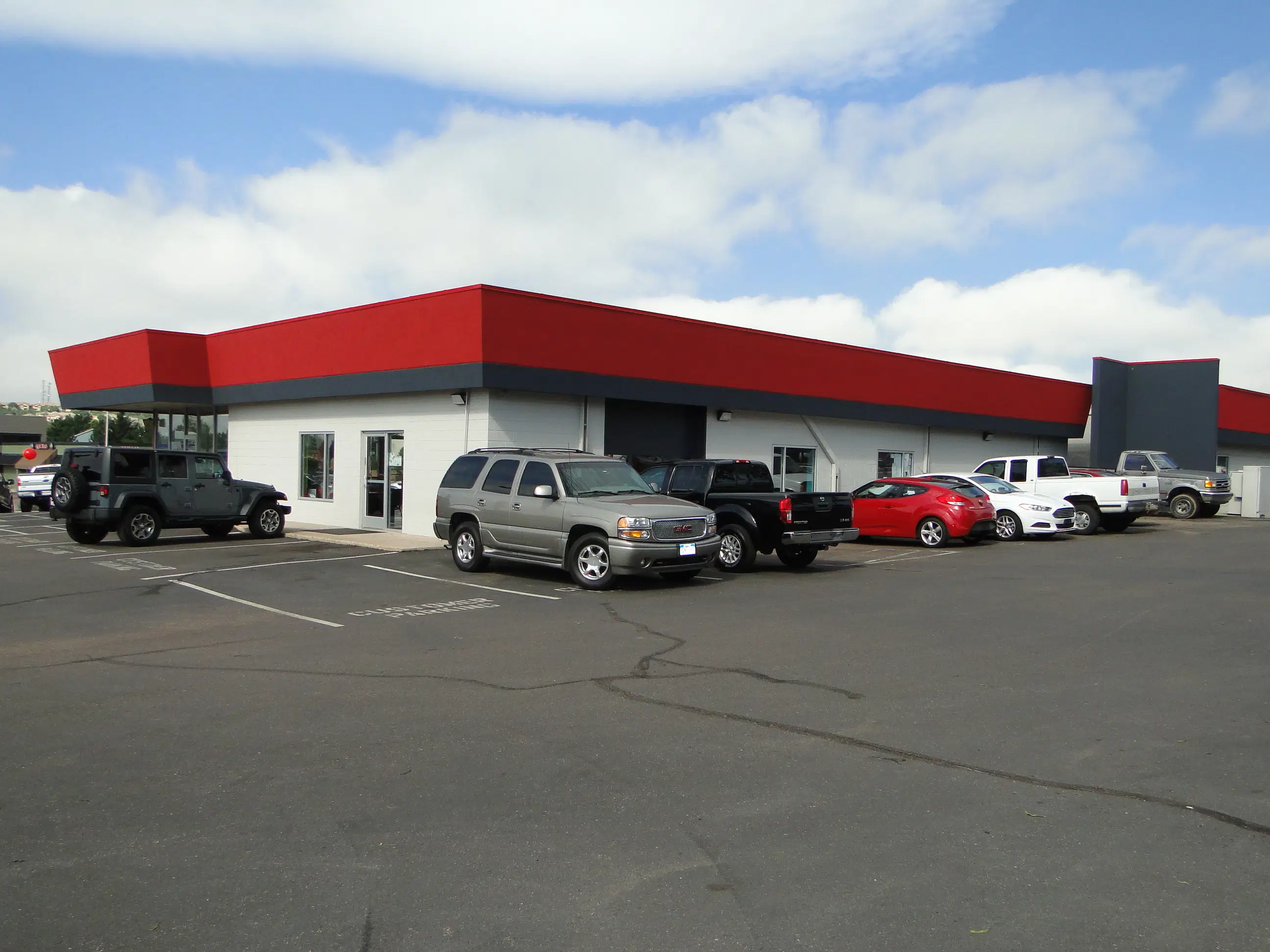 Exterior of the McCloskey Truck Town building with pre-owned vehicles in Colorado Springs CO
