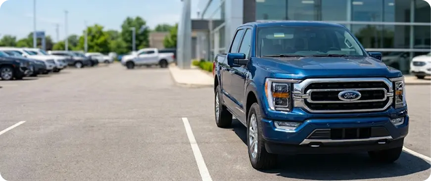 Row of used pickup trucks parked in a dealership lot