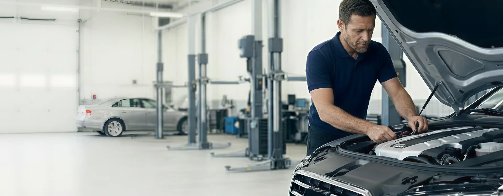 Certified technician replacing a car battery at the Merit Auto Group service center