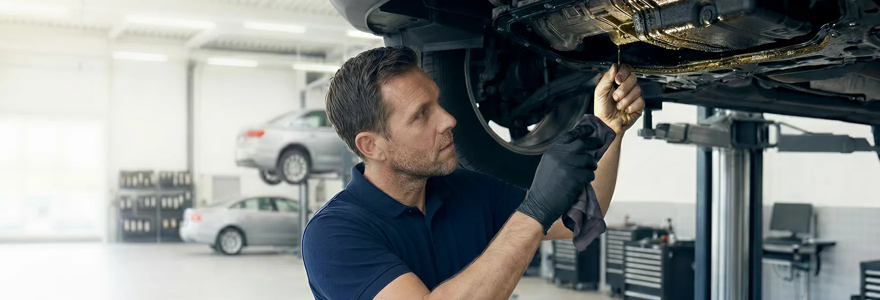 Vehicles being serviced on lifts inside the Merit Auto Group service center