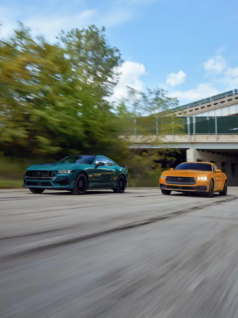 Green and orange Ford Mustangs driving to show bold exterior color options