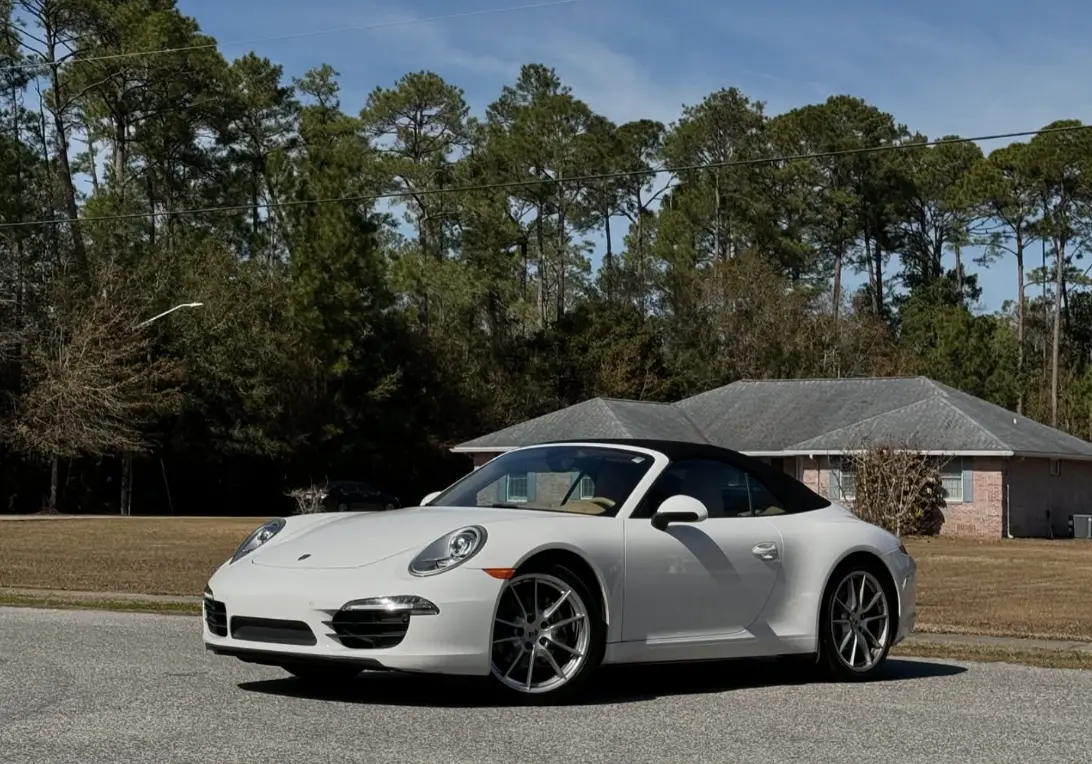 White Porsche 911 Cabriolet convertible parked on a residential street