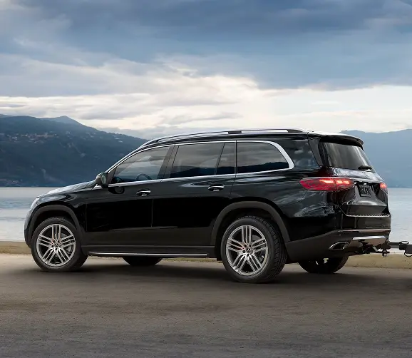 Black Mercedes-Benz GLS parked by a lake, side profile