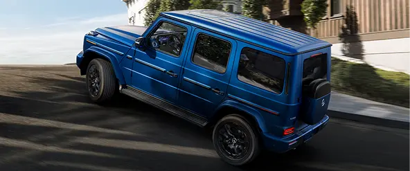 Blue Mercedes-Benz G-Class driving, side profile