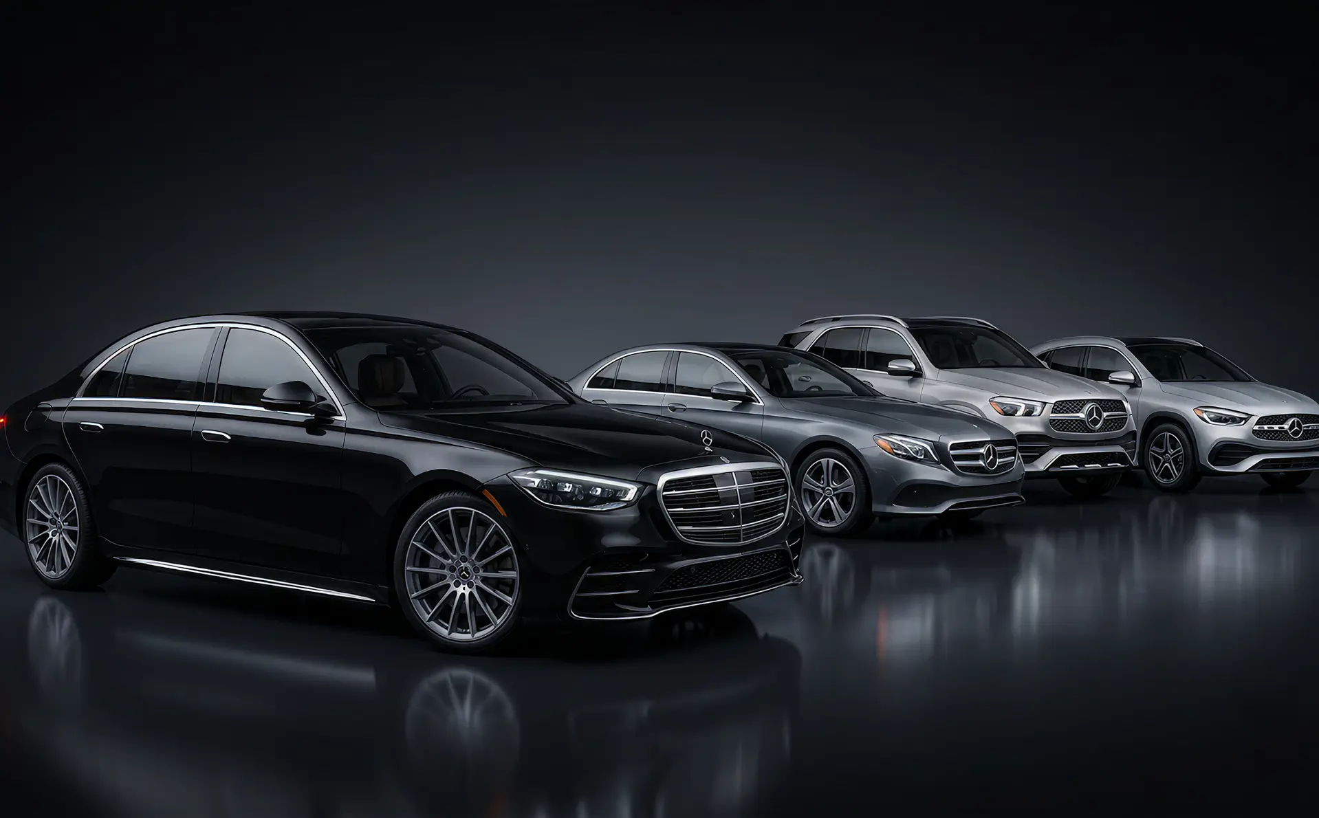 A lineup of used Mercedes-Benz vehicles — a black S-Class sedan, gray E-Class, GLE SUV, and silver GLA — in a dark studio