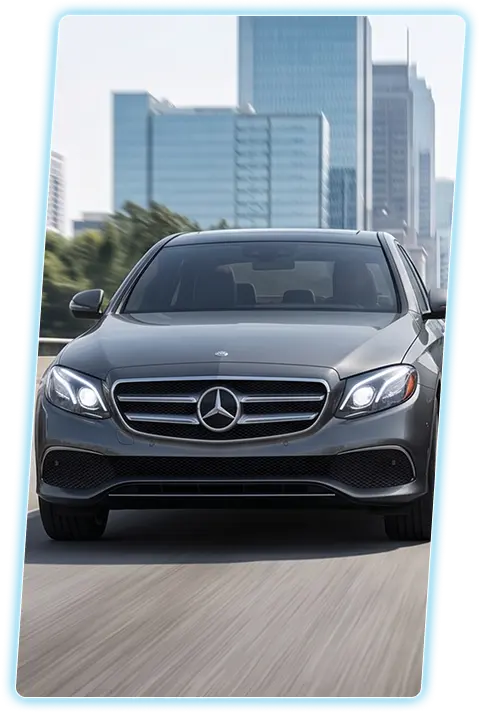 Gray Mercedes-Benz E-Class front view against a city skyline