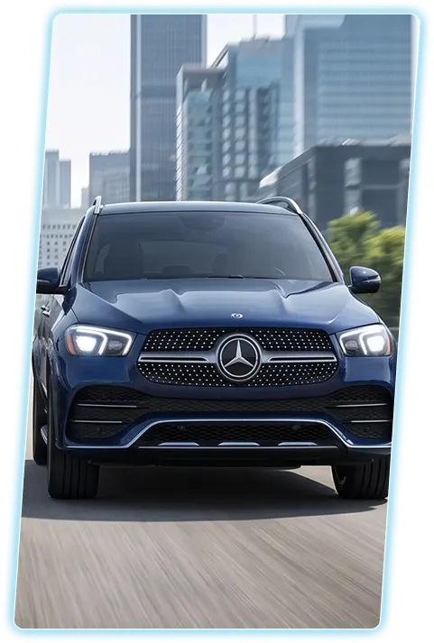 Blue Mercedes-Benz GLE front view against a city skyline