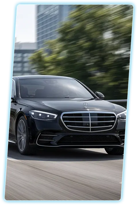 Black Mercedes-Benz S-Class front view against a city skyline