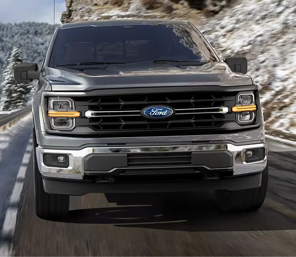 Gray Ford F-150 front view on a snowy mountain road