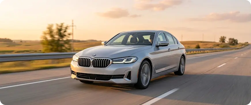 Used sedan driving on an open road