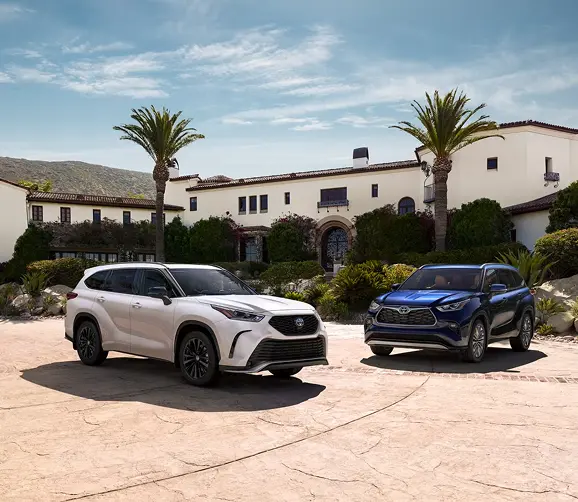 White and blue Toyota Highlanders parked outside a Spanish-style house