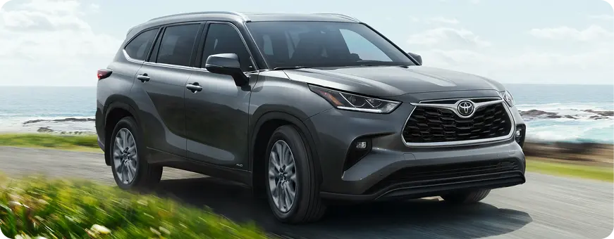 Gray Toyota Highlander driving on a coastal road