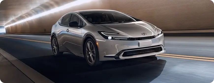 Silver Toyota Prius Prime driving on the road, front three-quarter view