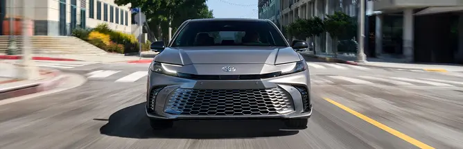 Silver Toyota Camry driving toward the camera, front view