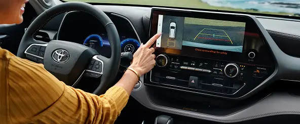 Driver using the Toyota Highlander touchscreen infotainment display