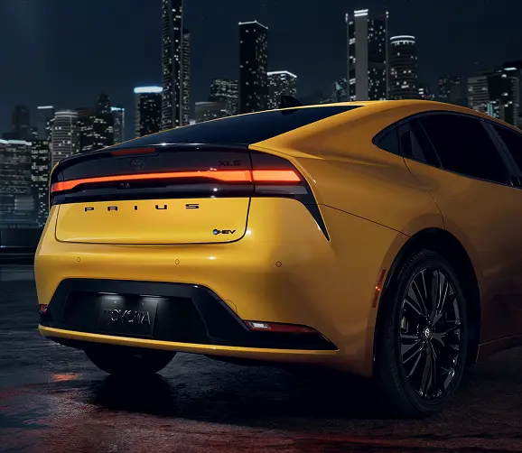 Yellow Toyota Prius Prime, rear three-quarter view showing the light bar