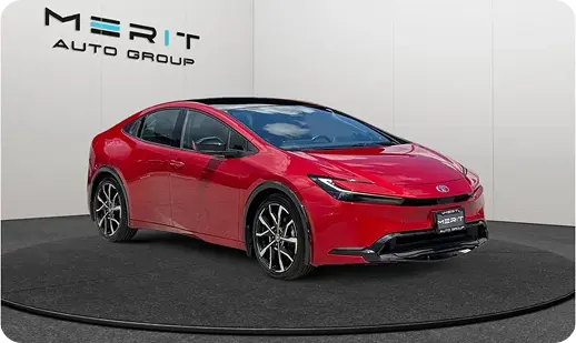 Red Toyota Prius Prime on a studio turntable, front three-quarter view