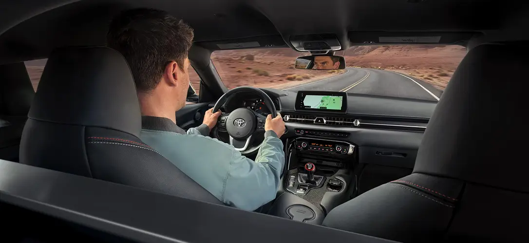 Toyota GR Supra driver-focused cockpit with the steering wheel and digital display