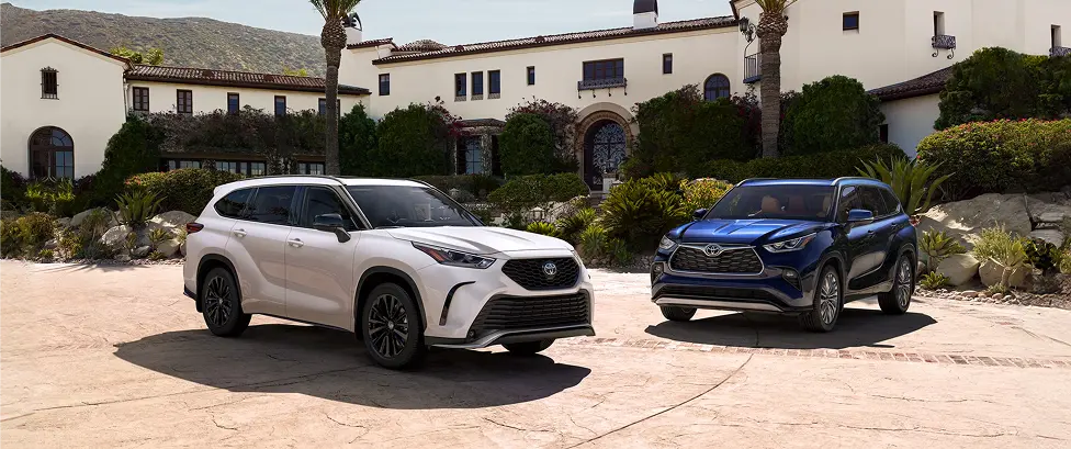 White and blue Toyota Highlander SUVs parked in front of a Spanish-style estate