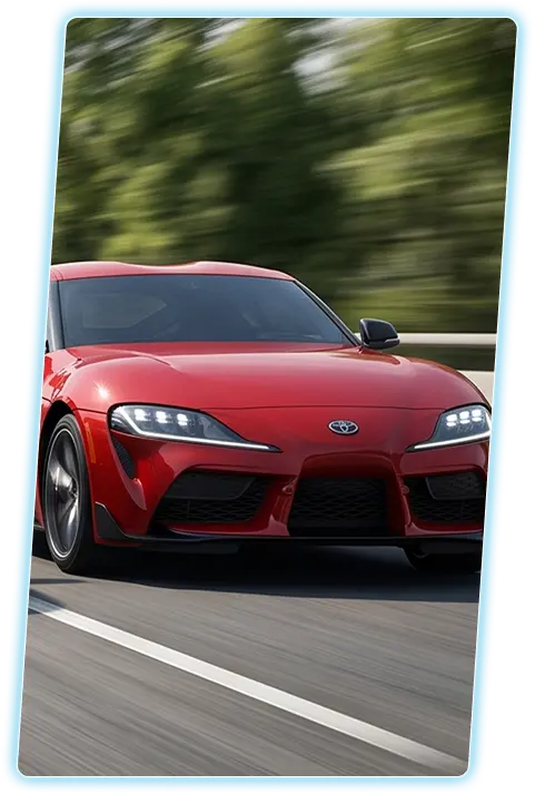 Red Toyota GR Supra front view against a city skyline