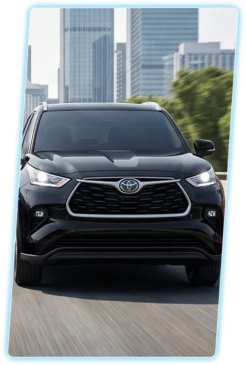 Black Toyota Highlander front view against a city skyline