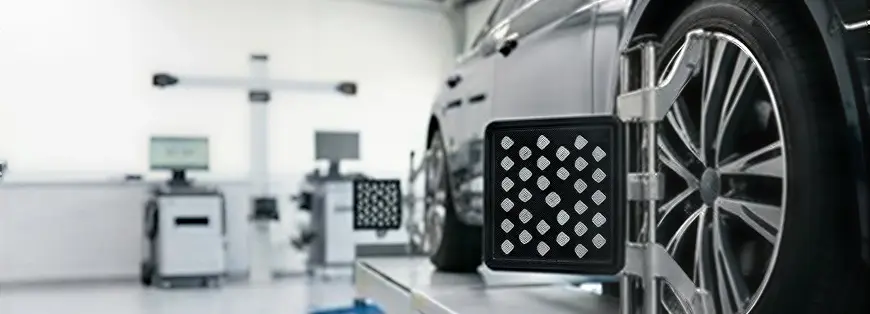 Wheel alignment machine with target sensors mounted on a vehicle's wheels in the alignment bay