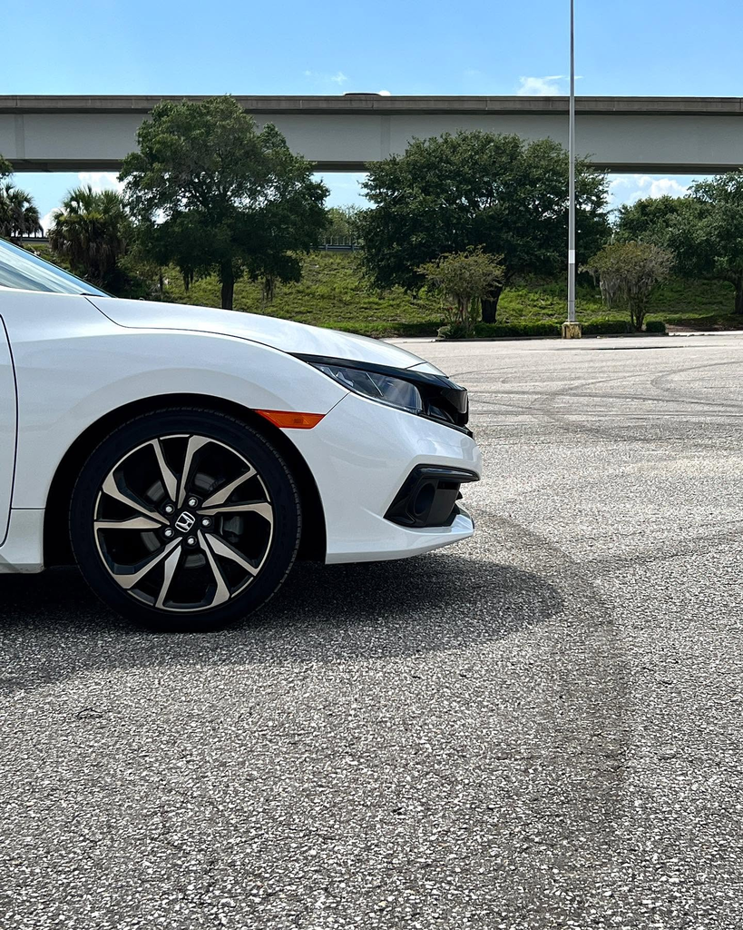 Close detail of a white Honda Civic front wheel and tyre.