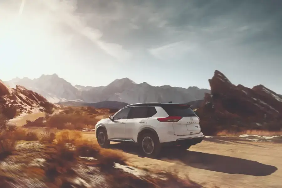 Exterior of a Nissan Rogue driving on a dirt road