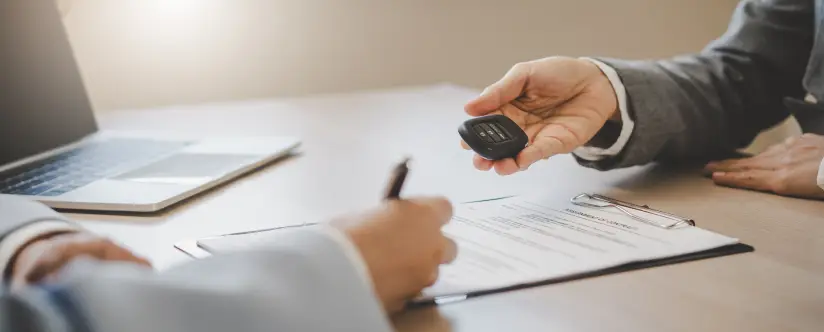 Buyer signing financing paperwork and receiving truck keys