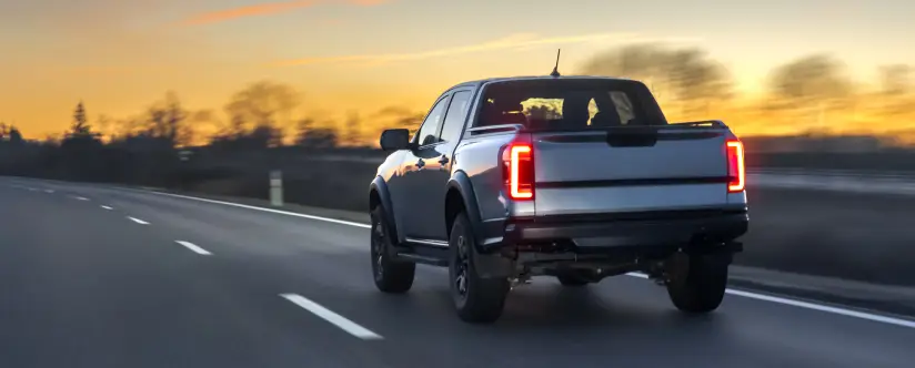 Diesel pickup truck on the highway at sunset, nationwide shipping