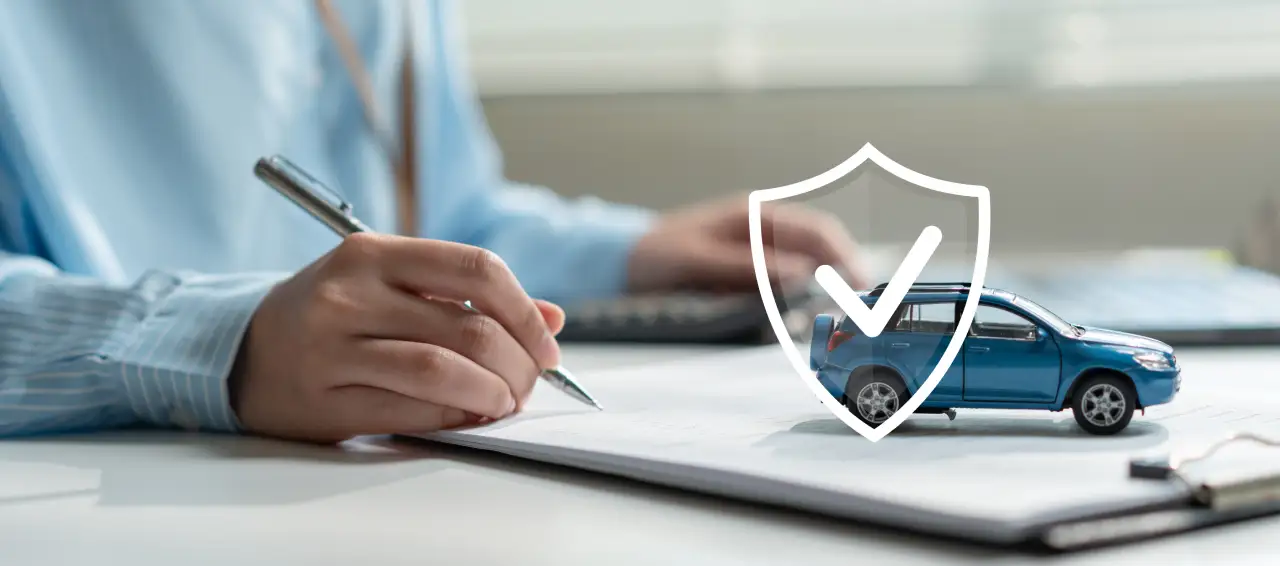 Customer signing vehicle paperwork with a protection/warranty icon over a car