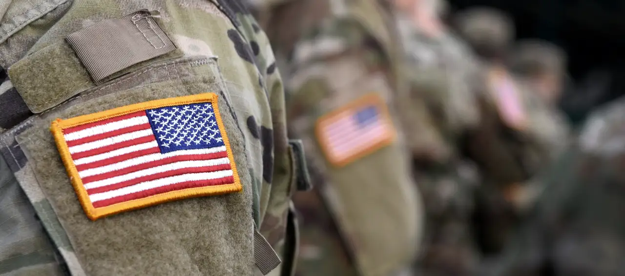 Close-up of American flag patches on military uniforms, representing service members