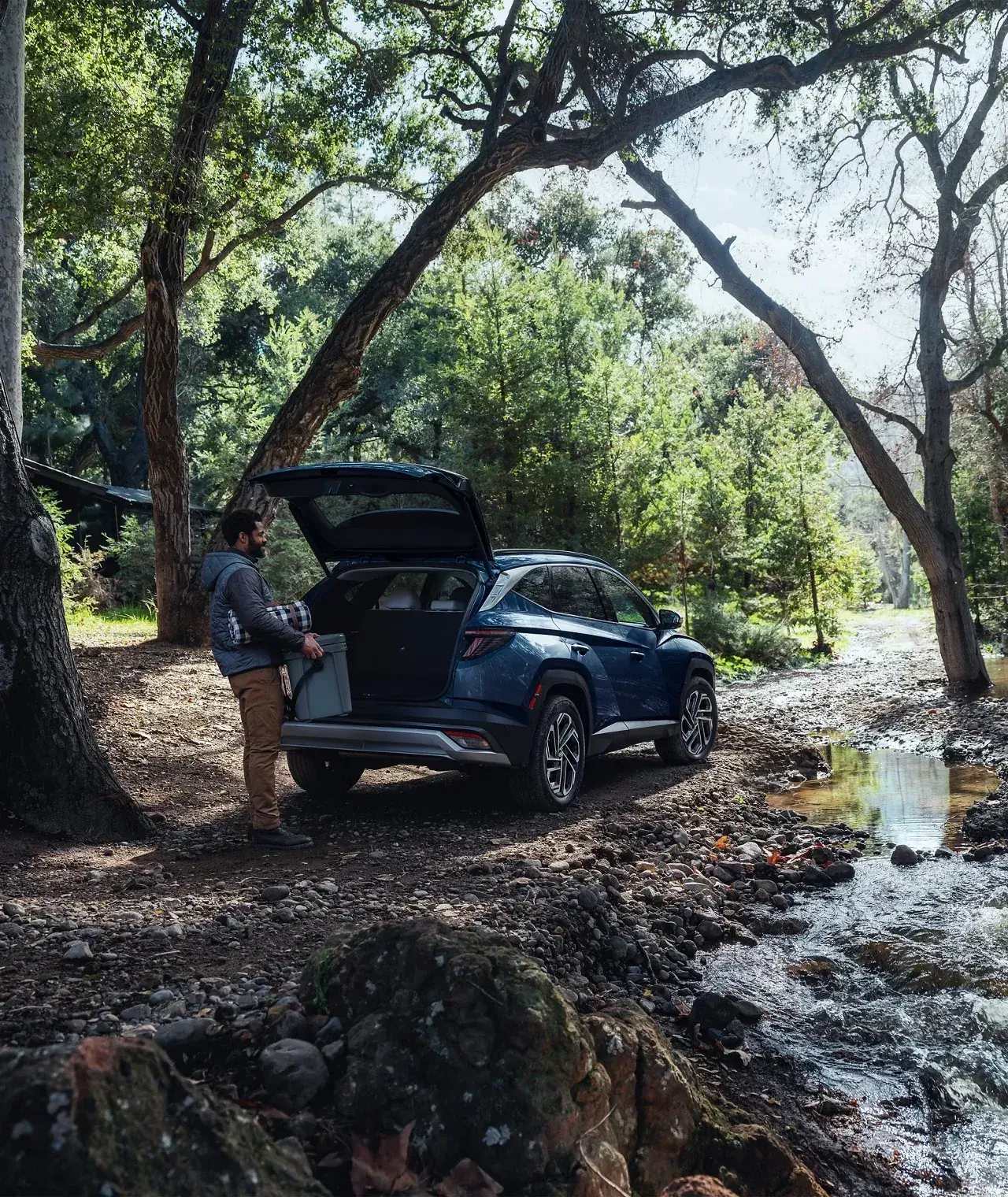 2026 Hyundai Tucson with its liftgate open beside a shaded creek, rear view